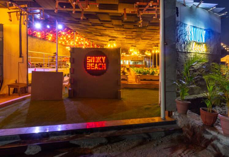 Night view of Smoky Beach restaurant entrance with neon signs and ambient lighting