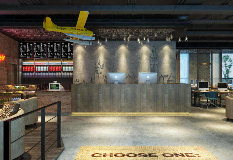 Trendy café counter with two iMacs, wall art, yellow airplane decor, and cozy seating areas.