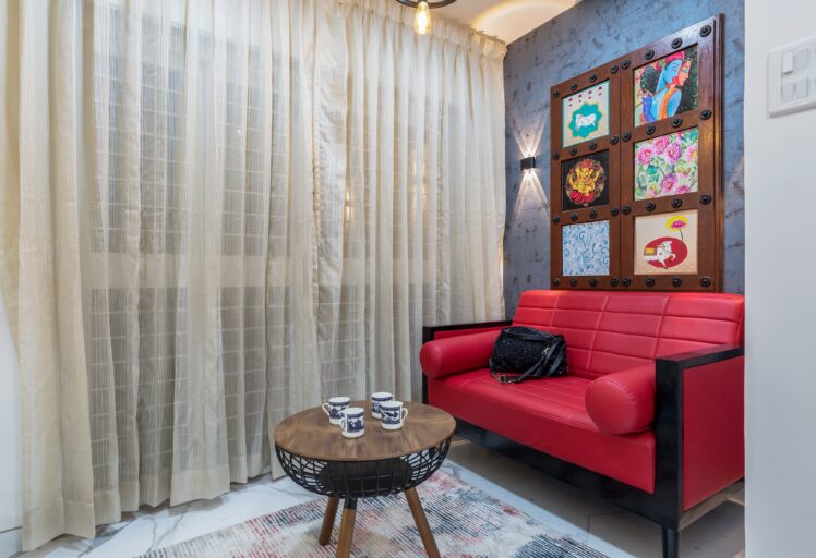 Cozy corner with red sofa, round coffee table, and colorful wall art panels