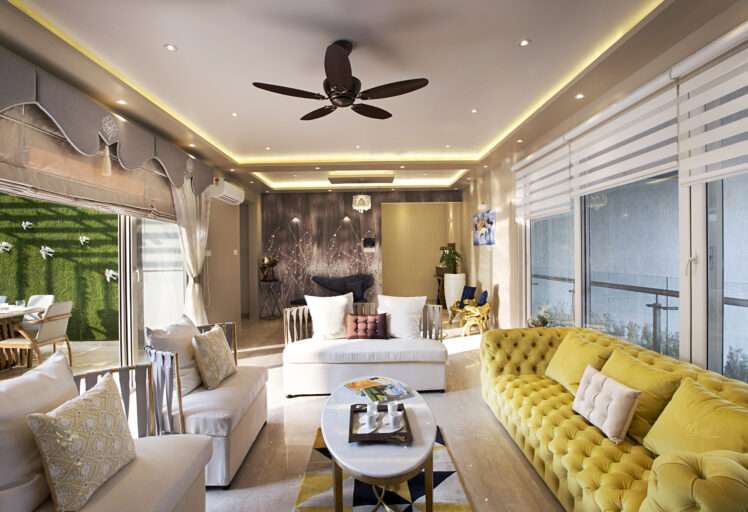 Chic living room interior design with cozy seating, ceiling lights, and natural window lighting.